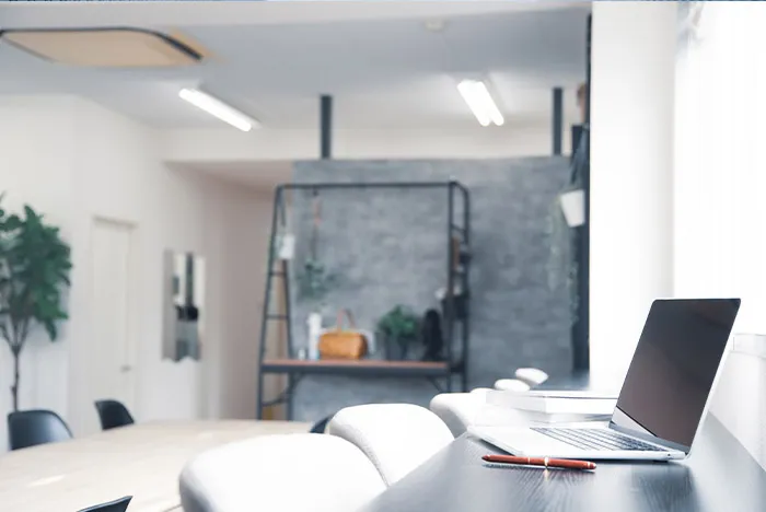 窓際のカウンターテーブルにノートパソコンが置かれた会議スペース。